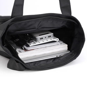 Spacious black water-resistant nylon shoulder bag showing laptop and daily essentials