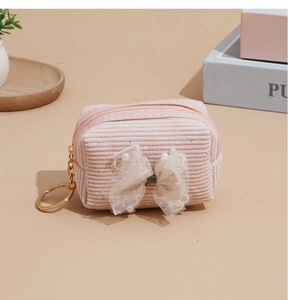Detailed close-up of pink corduroy mini coin purse with lace bow and pearl accent
