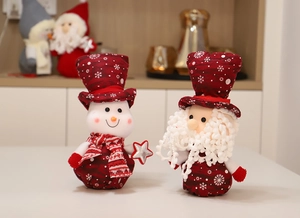 Detail of plush Christmas Santa and Snowman figures with snowflake hats and silver stars