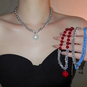 Detail of layered zircon pearl necklace with crystal beads and large pendant on model