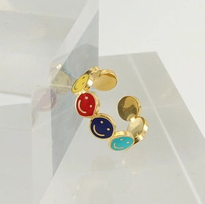 Macro shot of 18k gold plated ring featuring colorful enamel smiley faces on clear blocks