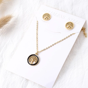 Detail of 18k gold tree of life jewelry set with black enamel border on card