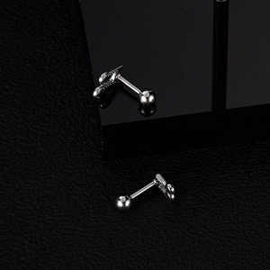 Macro shot of silver musical note stud earrings with threaded ball back on leather