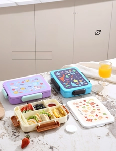 Top view of four-compartment bento box with unicorn, dinosaur, and bear cartoon lids