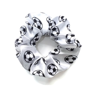 Detailed view of the soccer print satin scrunchie with smooth white fabric and elastic band