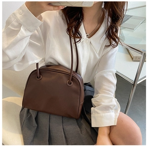 Minimalist deep brown retro shoulder bag styled with a white shirt and grey pleated skirt