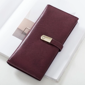 Slim burgundy matte leather wallet for women with gold clasp closure on a magazine