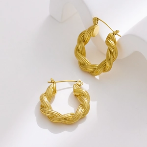Detailed close-up of golden twisted rope hoops with metallic texture and snap closure