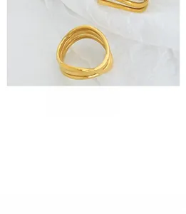 Detailed macro view of 18K gold plated multi-layer wave textured ring on white fabric