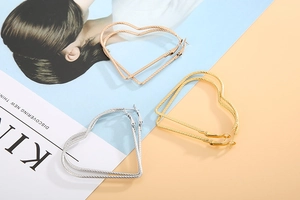 Detailed view of heart-shaped twisted hoop earrings in gold, silver, and rose gold finishes