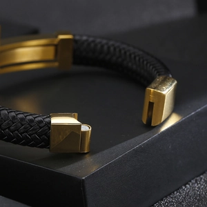 Close-up of black braided leather bracelet with golden magnetic clasp on luxury box