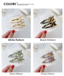 Cat-shaped acetate hair clips in four marble patterns shown on a white display card