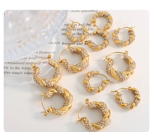 Detail view of twisted gold-plated hoop earrings with micro-set cubic zirconia stones