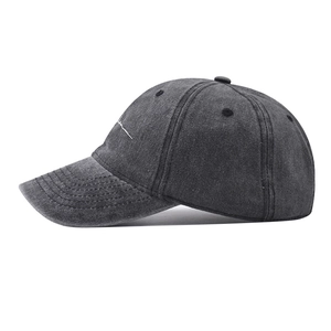 Detail shot of white cursive embroidery on washed charcoal grey cotton baseball cap
