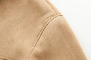 Détail macro des coutures d'épaule d'une veste courte en daim de couleur chameau