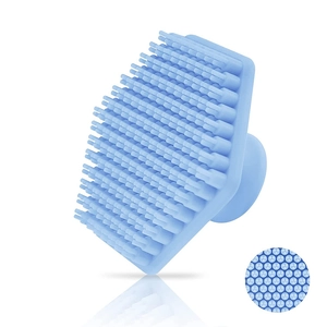 Close-up of soft blue silicone bristles and suction handle on a hexagonal face brush
