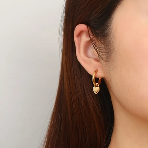 Élégantes boucles d'oreilles cœur en acier inoxydable doré portées par un mannequin