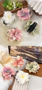 Detail view of large 3D fabric flower hair claws in multiple pastel gradient colors