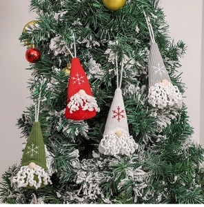 Close-up of four knitted Christmas gnomes with snowflake embroidery on a tree