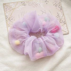 Detail of light purple mesh scrunchie filled with colorful plush rainbow balls