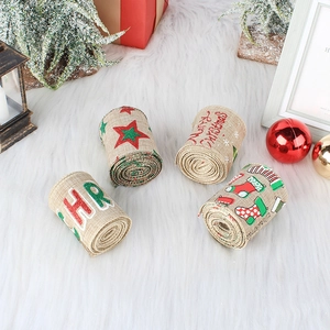Four rolls of Christmas wired burlap ribbon with festive prints on white plush background
