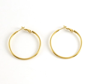 Detailed macro view of pair of 18K gold plated stainless steel polished hoop earrings