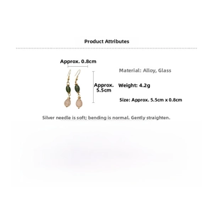 Detail view of water-drop faux glass earrings with gold hooks and green beads