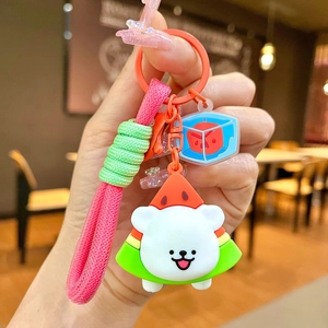 Close-up of a cartoon dog keychain with watermelon costume and pink braided lanyard