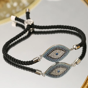 Macro detail of evil eye bracelet with blue marquise crystals on a black braided cord