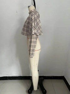 Detail of khaki plaid layered cropped top with long sleeves and shrug design