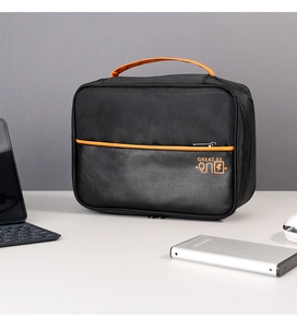 Detail of nylon and PU leather digital storage bag with orange handle and GREAT logo