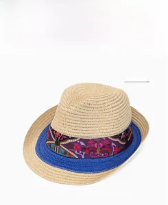 Detailed weave of beige straw sun hat featuring a purple bohemian ribbon and blue trim edge