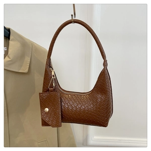 Close-up of brown woven texture shoulder bag with matching coin purse and gold hardware