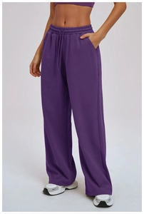 Detail of purple wide-leg sports pants featuring elastic drawstring waist and side pockets