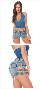 Detalle de pantalones cortos vaqueros con hebillas metálicas laterales y deshilachado