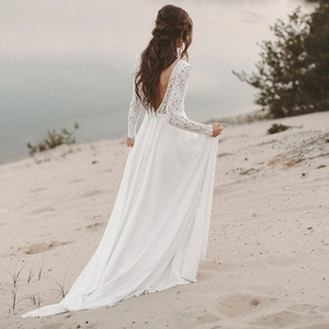 Detailed back view of a bohemian white lace long sleeve wedding dress with an open back