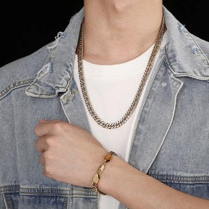 Close-up of gold-plated Cuban chain necklace and bracelet set on a fashion male model