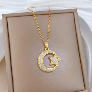 Macro shot of gold star and crescent moon pendant with sparkling cubic zirconia on silk