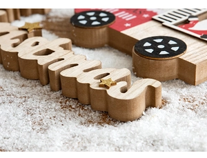 Close-up of wooden Christmas sign and red truck ornament with natural wood grain