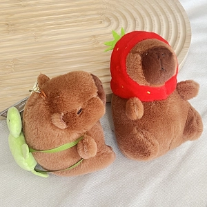 Schattige capibara pluche sleutelhanger met aardbeienhoed en schildpad rugzak op dienblad
