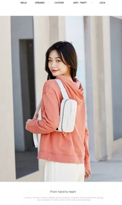Detail of waterproof beige crossbody bag with monogram print and anti-theft lock