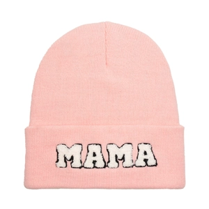 Close-up of pink knit beanie featuring MAMA chenille letter patch and soft textures