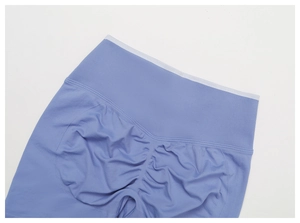 Dettaglio degli shorts sportivi a vita alta senza cuciture lilla con effetto scrunch
