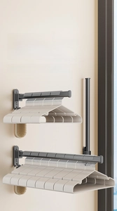 Detail of wall-mounted folding hanger organizer in matte black metal with dual rack setup