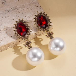 Detail view of vintage oval red gemstone earrings with pearls and champagne crystal border