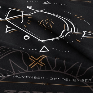 Close-up of Sagittarius constellation print on black fabric with November December dates