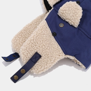 Dettaglio del cappello da aviatore in tela blu con fodera in peluche e occhielli in metallo