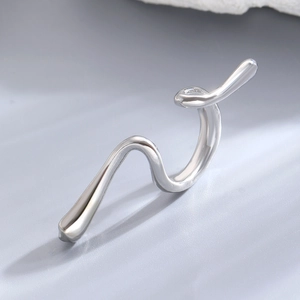 Macro shot of minimalist silver irregular wavy earring with a polished metallic finish