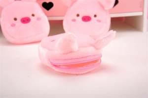 Detail view of the plush pink pig coin purse showing zipper closure and soft material