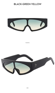 Detail of wide black frames with green yellow gradient lenses and metal side dots